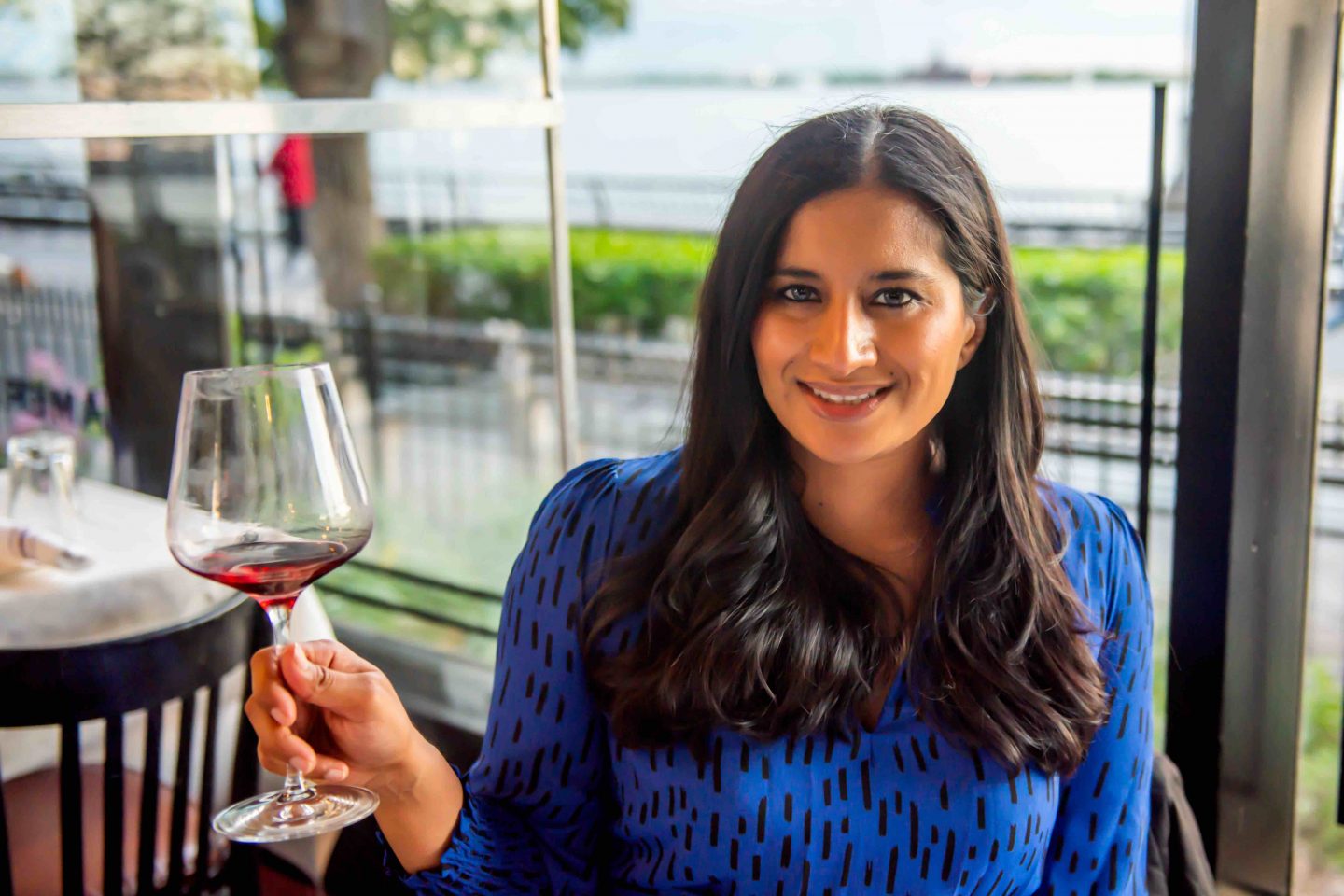 The Best Battery Park Restaurants in 2021: Merchants River House Best Battery Park Restaurants in 2021. Merchants River House – Woman Holding a Glass of Red Wine