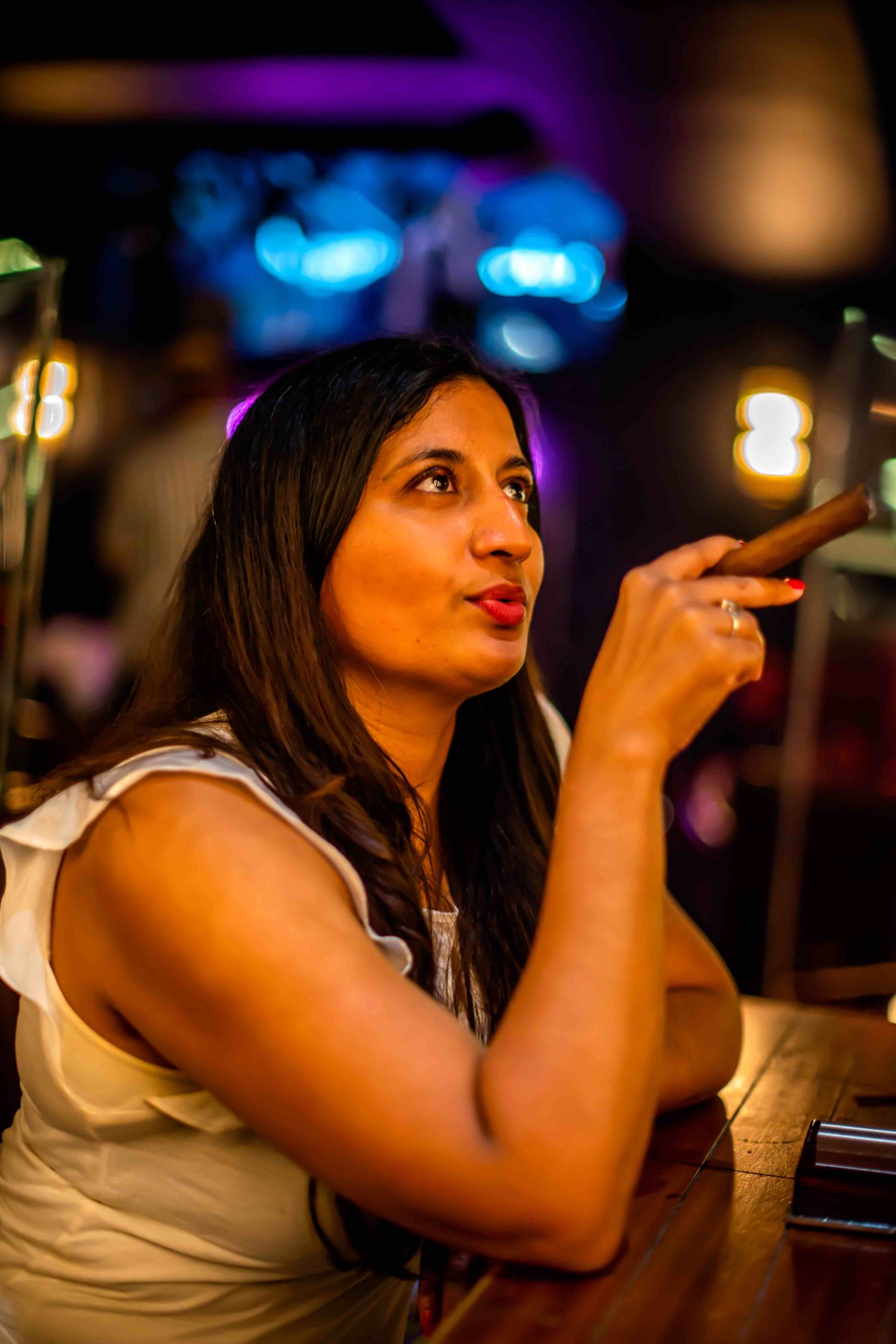 Best Cigar Bars in NYC in 2021: Merchants Cigar Bar Merchants Cigar Bar - Woman Holding a Cigar. Best Cigar Bars in NYC.