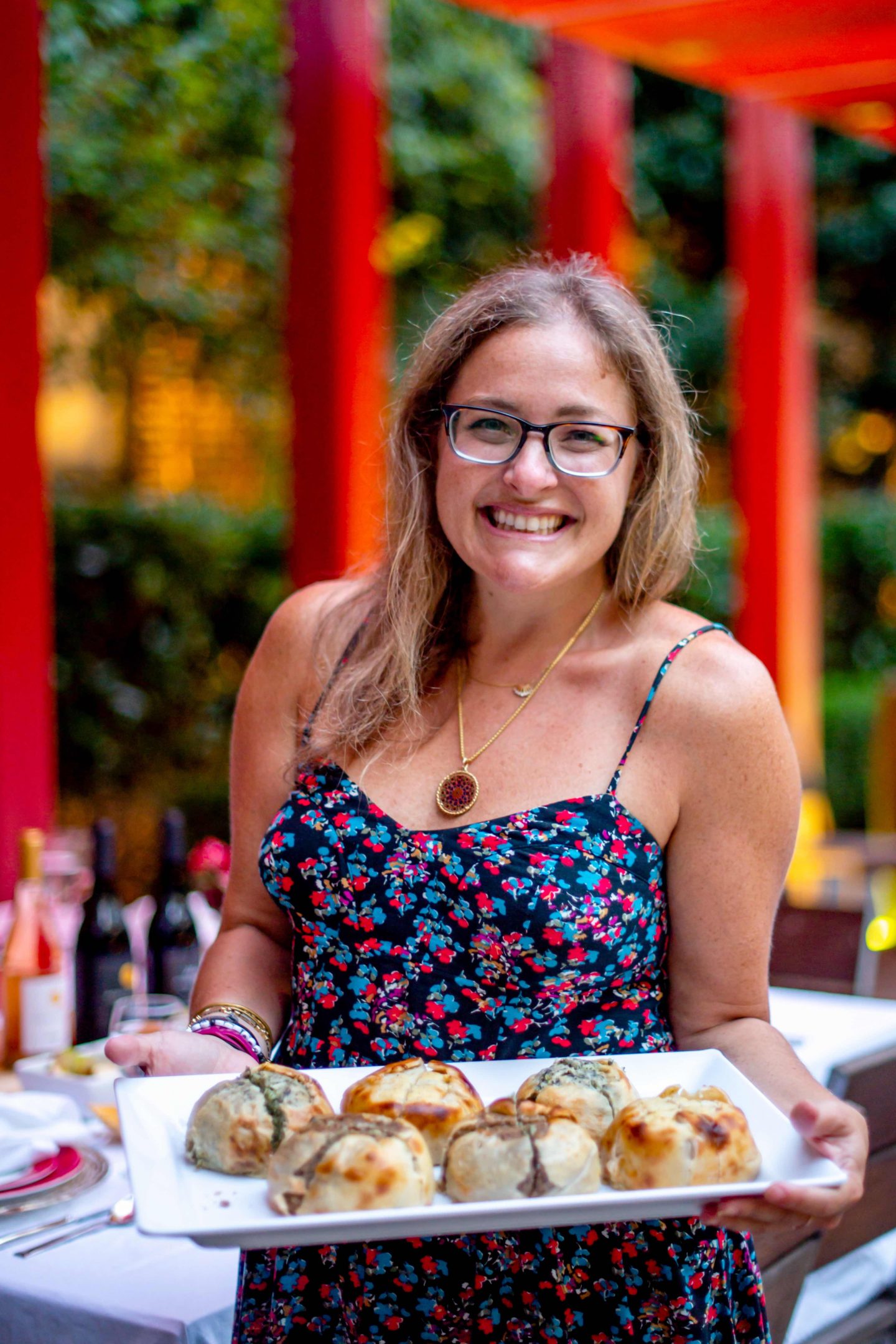 The Best Fall Dinner Party Ideas in 2021 Rosh Hashanah - Woman holding a tray of Knishes. Fall Dinner Party Ideas.
