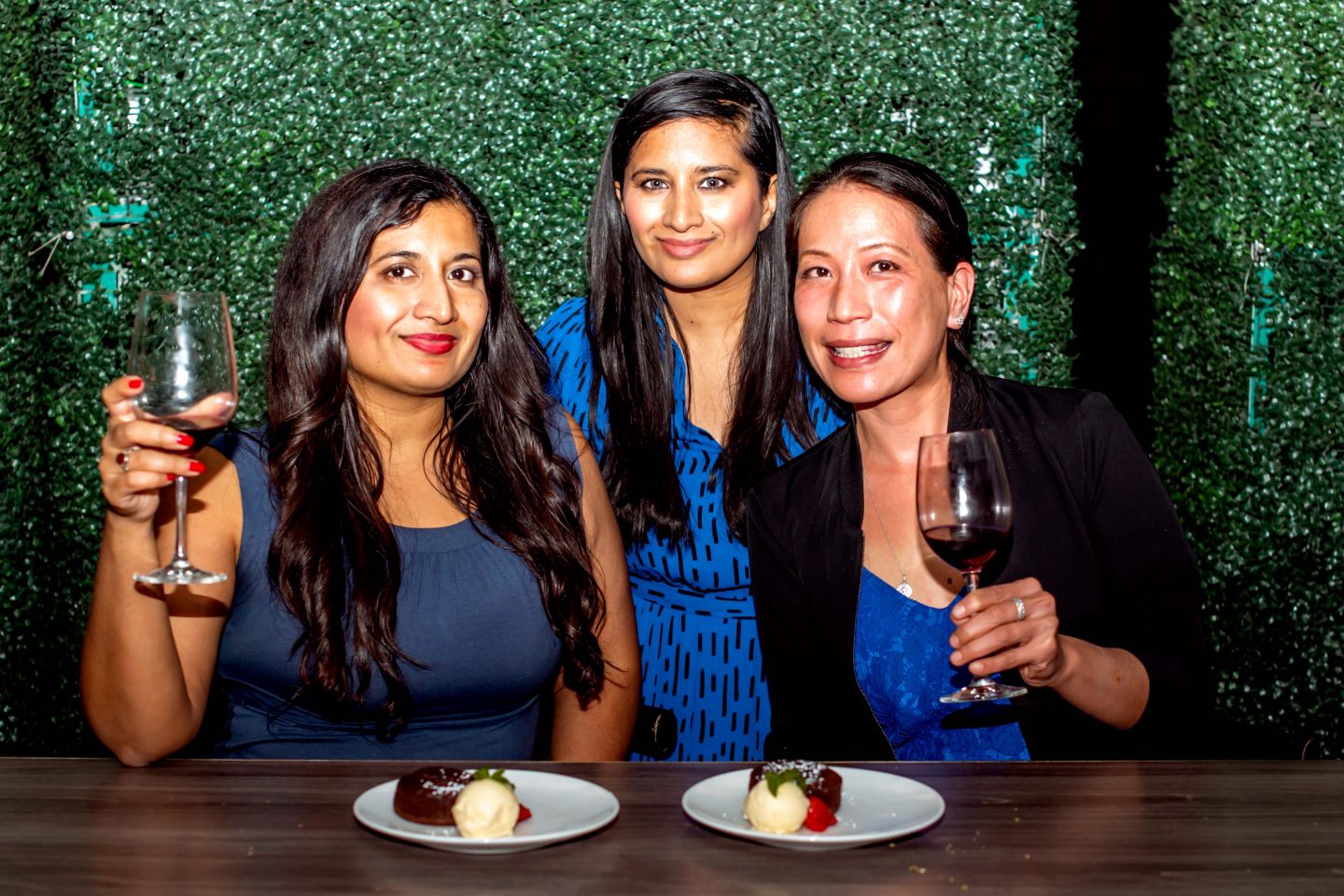 Versa Rooftop. Women Holding Glasses of Red Wine. Dark Chocolate Cake with Ice Cream. Best Rooftops in Midtown Manhattan.