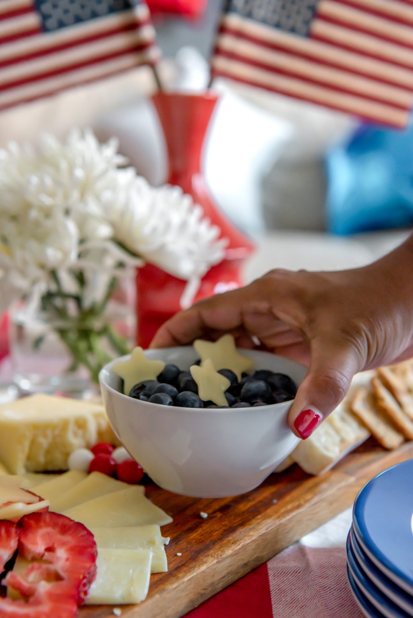 Best July 4th Decor Ideas: How to Celebrate Independence Day in Style July 4th Decor Ideas. Red, white and blue cheese board. Red and white gingham tablecloth. American flags.