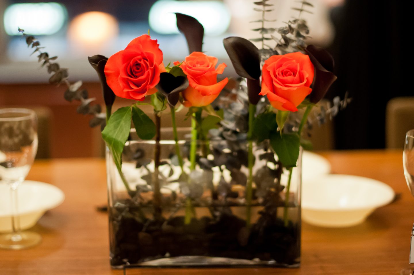 Halloween dinner party. Halloween table. Orange and black Halloween tablescape. Orange roses and black calla lilies. 