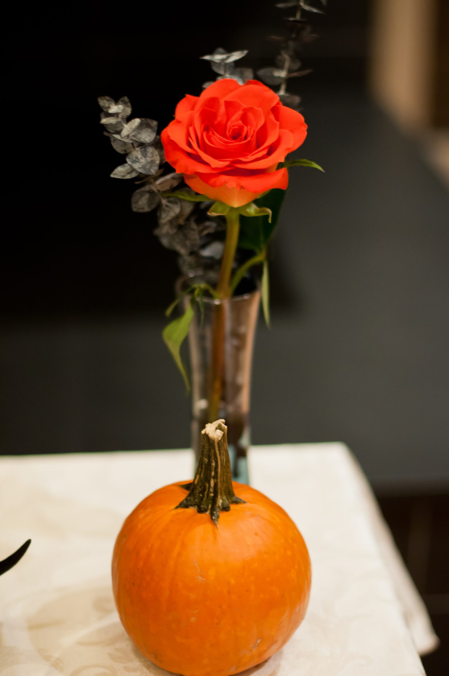 Halloween dinner party. Halloween table. Orange and black Halloween tablescape. Orange roses. 